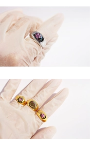 Close-up of rings featuring pink star zircon, smiley face, and flower designs on model