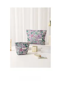 Detail shot of two French vintage floral jacquard makeup bags with HAR BAG woven label