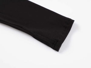 Close-up of black ribbed knit bodysuit sleeves featuring functional thumbhole detail