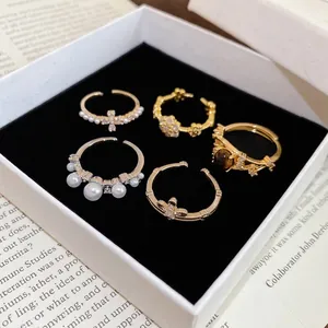 Elegant 5-piece French gold ring set with white pearls and zircon on black velvet