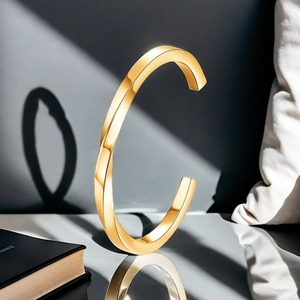 Macro shot of twisted gold bangle with polished finish and unique geometric C-shape design
