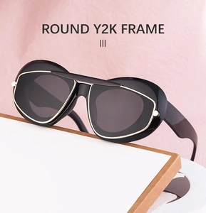 Detail of black round Y2K sunglasses with golden metal wire frame and dark lenses