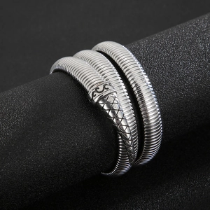 Macro shot of silver snake-shaped coiled bracelet showing textured scales and head detail