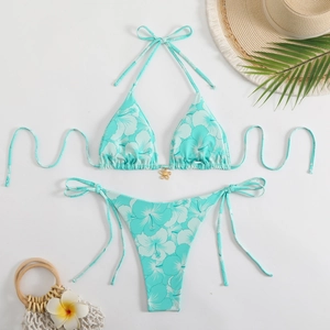 Detail of teal tropical floral bikini set with gold flower charm and side-tie bottom