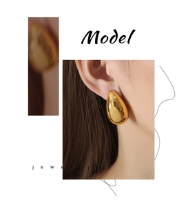Macro detail of gold-plated teardrop earrings showing the polished mirror finish and smooth curve