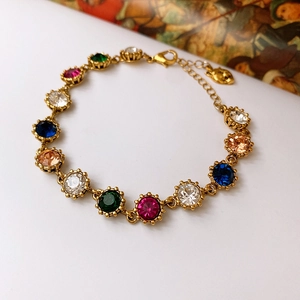 Detailed close-up of a vintage baroque gold chain necklace with colorful gemstones and a rabbit charm
