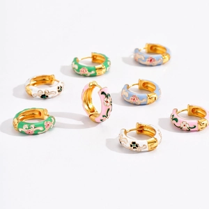 Macro detail of enamel flower hoops with vintage floral patterns in multiple colors
