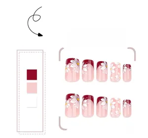 Detailed view of red and pink press-on nails with white floral daisy patterns