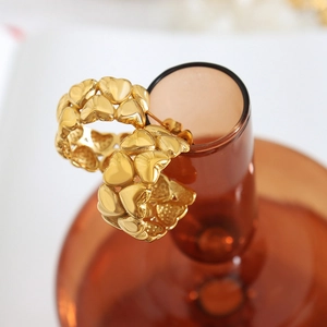 Creative 18K gold plated heart拼接 hoop earrings displayed on a glass rim