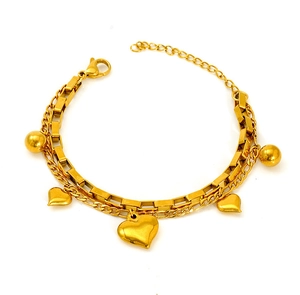 Détail du bracelet doré double chaîne avec pendentifs en forme de cœur et billes