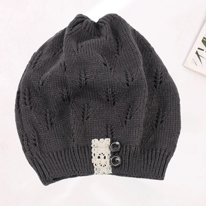 Detailed view of grey knitted beanie featuring leaf openwork pattern, lace trim, and buttons.