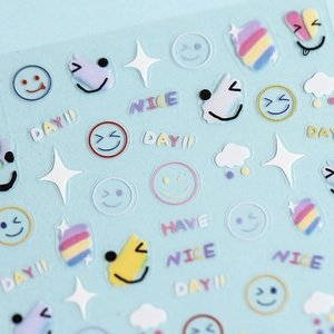 Rainbow smiley face 3D nail stickers with macaron clouds and star patterns on blue background