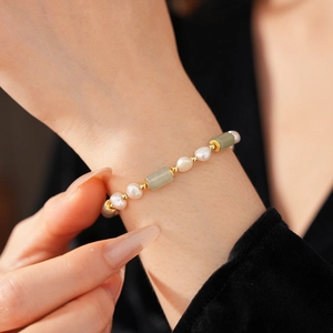 Detail of freshwater pearl and green bamboo jade bracelet with gold plated beads