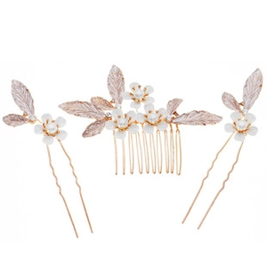 Detailed view of floral bridal hair comb and pins with pearls and rose gold leaves