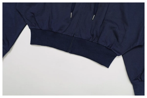 Detailed macro view of navy blue hoodie featuring ribbed hem, cuffs and metal zipper