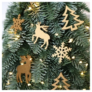 Macro shot of laser-cut wooden elk and snowflake ornaments on a Christmas tree