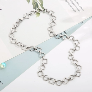 Detail of silver stainless steel chain with alternating square and floral link design