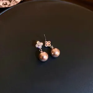 Elegant rose gold clover earrings with sparkling pavé crystals and champagne pearls