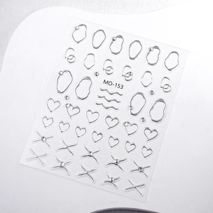 Detail view of silver embossed nail stickers with heart and cross motifs with rhinestones