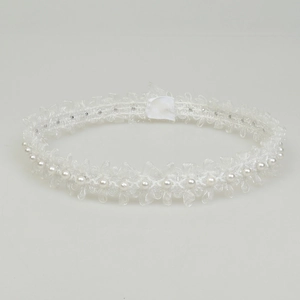 Close-up of a white bridal lace garter belt with elegant pearls and sparkling rhinestones