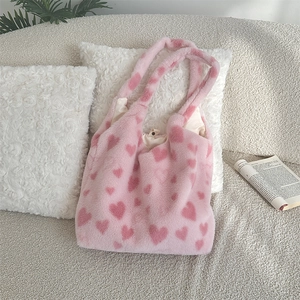 Detail of pink plush heart tote bag featuring soft faux fur texture and magnetic closure