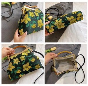 Detail view of vintage black shell bag with yellow floral embroidery and wood handle