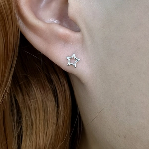 Elegant S925 sterling silver hollow star stud earrings on a female model's earlobe