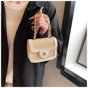 Detail of mini woven straw handbag with white leather trim and golden flower buckle