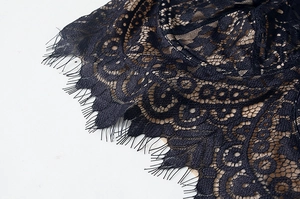 Detailed close-up of intricate black eyelash lace and floral embroidery on a bra