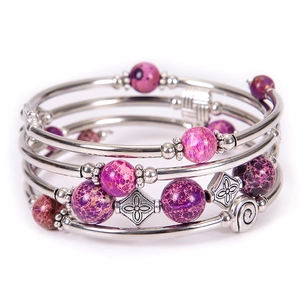 Detailed macro view of multi-layer bracelet with purple stones and silver spiral charms