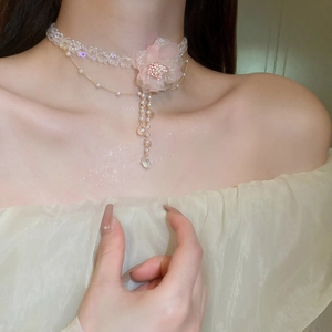 Detail of pink lace flower necklace with pearls and crystal tassel on model neck
