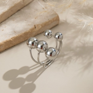 Macro shot of silver minimalist triple-band ring with five polished spheres on stone