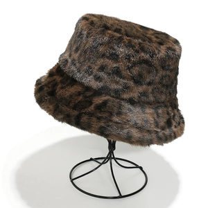 Detail of warm faux fur leopard print bucket hat on a black metal display stand