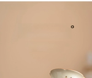 Close-up of celadon Ru kiln porcelain tea cup with dandelion and cute rabbit motifs