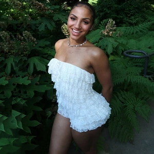 Detail of white layered lace tube jumpsuit showing fabric texture against green foliage