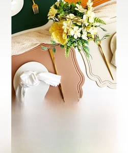 Close-up of heat resistant scalloped faux leather placemats in vintage colors