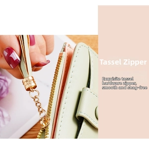 Detail of mint green leather wallet featuring golden zipper and matching tassel puller