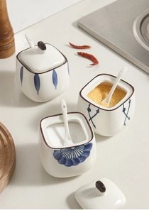 Close-up of Japanese style blue floral ceramic spice jars with matching spoons and lids
