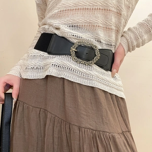 Détail de la ceinture élastique rétro avec boucle ovale en bronze gravée et sangle noire