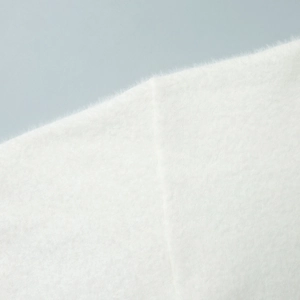 Close-up of the soft white knit fabric texture with long fluffy mohair fibers for comfort
