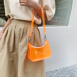 Transparent orange PVC jelly shoulder bag for women shown with a casual summer outfit