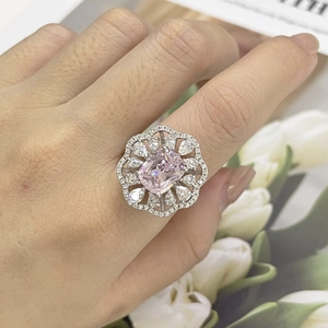 Macro view of rectangular pink diamond ring with floral micro-pave setting on a hand