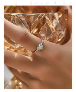 Close-up of elegant s925 silver ring featuring a round opal stone on a model's hand