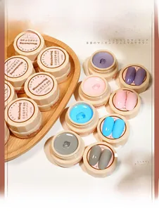 Close-up of 5ml solid gel nail polish pots in trendy colors on a wooden tray