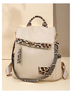 Detail of leopard print trim on beige oxford cloth backpack with tassel charm accent