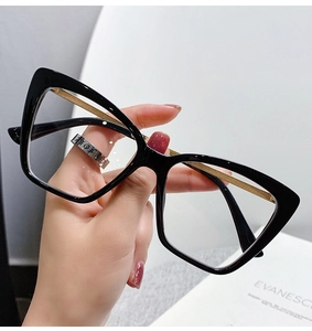 Detail view of stylish black cat-eye glasses with elegant gold metal temples and frame