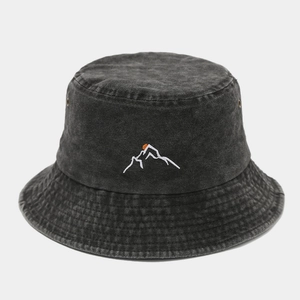 Close-up of mountain peak embroidery on washed denim fabric of a vintage bucket hat