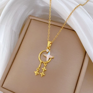 Detailed macro of gold celestial necklace with opal star and moon pendants on soft fabric