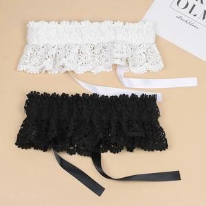 Detailed close-up of intricate floral lace garters in black and white with satin ribbons