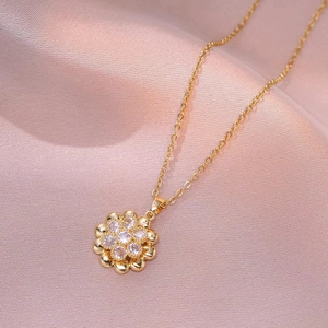 Collana rotante a fiore dorato con petali di zircone scintillanti su raso viola